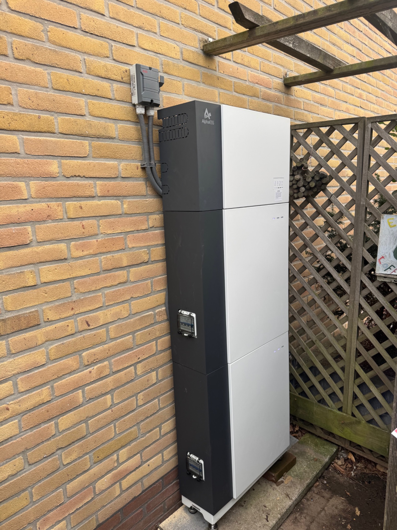 Door DBE geplaatst AlphaESS batterijsysteem bij een bakstenen muur